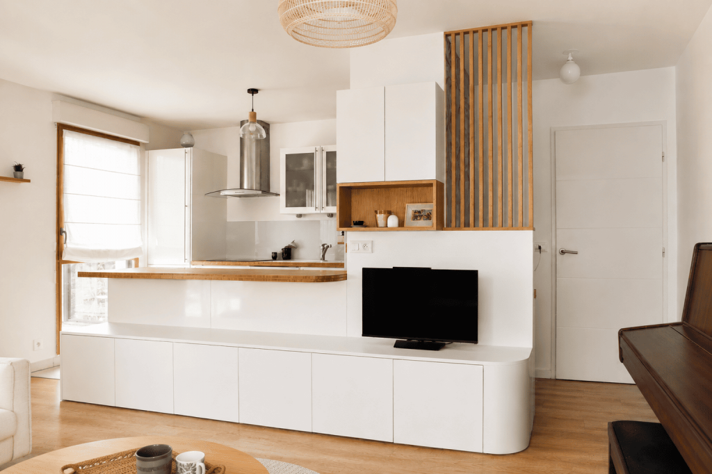 Optimisation d'espace avec ce meuble TV et bibliothèque sur mesure. Le claustra en chêne délimite un espace bureau discret et esthétique solution rangement astucieux appartement neuf