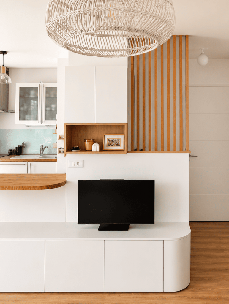 Meuble TV et bibliothèque sur mesure avec claustra en chêne délimitant un espace bureau discret et esthétique. Optimisation d'espace solution rangement astucieux appartement neuf optimisation espaces