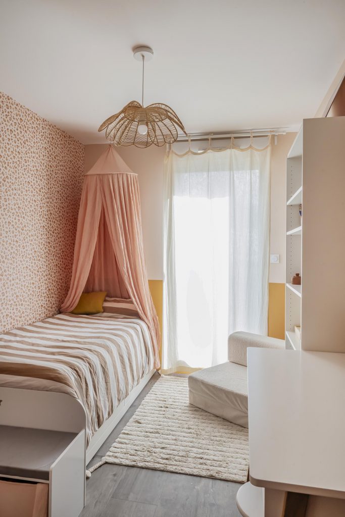 chambre fillette fille rose poudré papier peint peau de bête Graou bilboquet ciel de lit suspension rotin fleur étagères ikea livres aménagement chambre fille