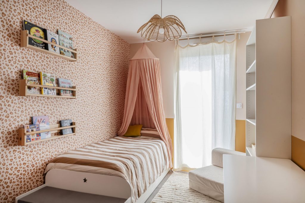 chambre fillette fille rose poudré papier peint peau de bête Graou bilboquet ciel de lit suspension rotin fleur étagères ikea livres aménagement chambre fille