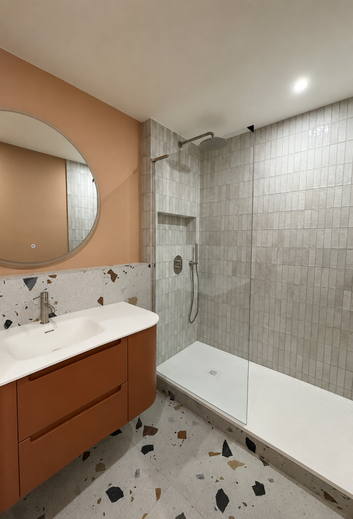 Salle d'eau colorée. Meuble vasque arrondi terracotta. Plan vasque intégré. Niche dans la douche. Robinetterie encastrée. Finition haut de gamme. TERRAZZO moderne. Salle d'eau contemporaine. Rénovation total appartement. Transformation salle d'eau